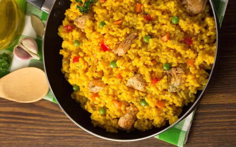 Plato de arroz con pollo casero con cilantro y ensalada fresca.